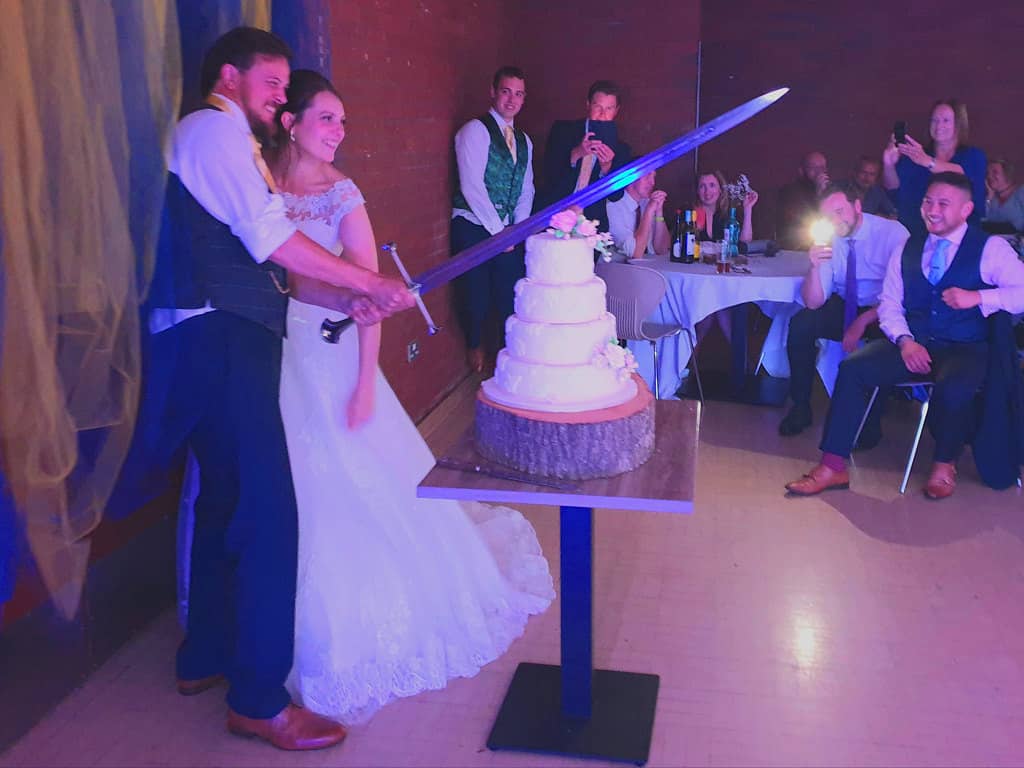 Cutting Wedding Cake With Sword Oswestry School Wedding Bride and Groom
